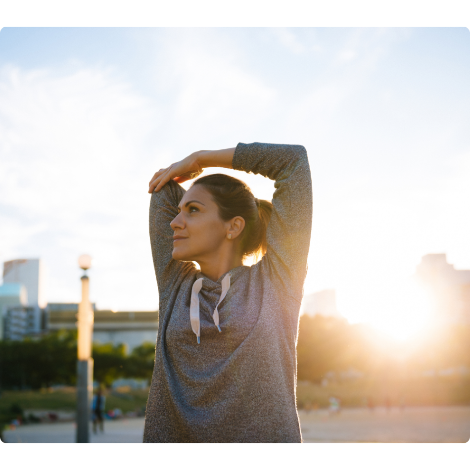 Woman Stretching Overhead in City Scape